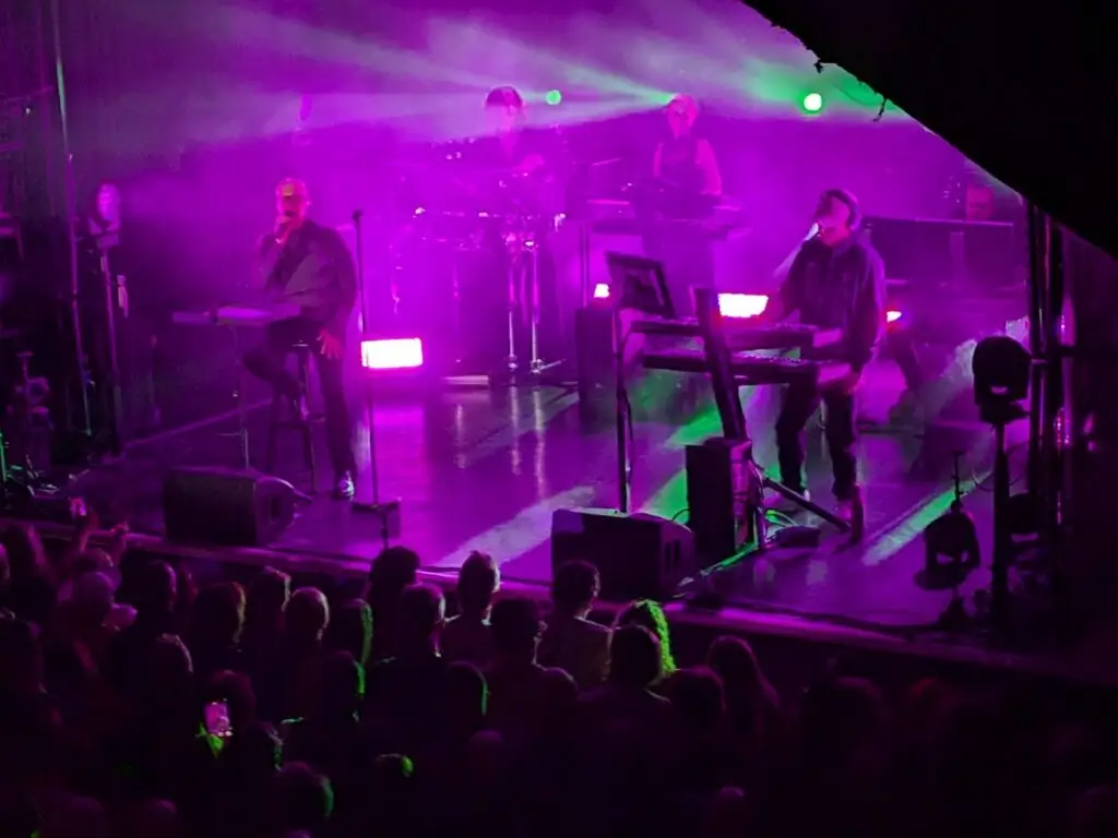 The Pet Shop Boys on stage bathed in purple light.