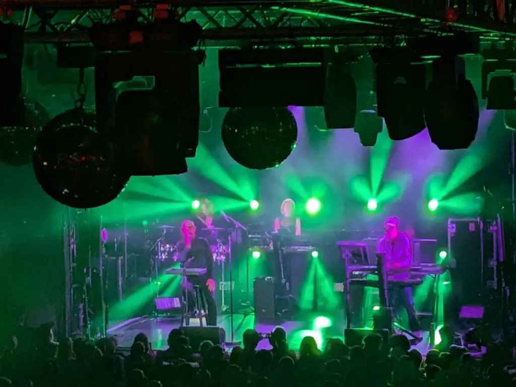 The Pet Shop Boys Perform. Purple and green lighting pulsates all around them.