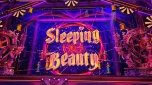 A purple sign with pink writing saying ‘Sleeping Beauty’.