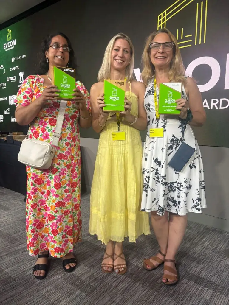 Eye Matter member Amrit, our founder Suzie and Jules from Jules&rsquo; Creative Content on stage, smiling brightly holding one of the awards.